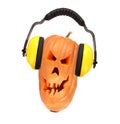 Scary evil face of pumpkin with headphones. Royalty Free Stock Photo