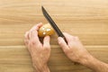 Scary face potato being cut on a wooden kitchen board Royalty Free Stock Photo