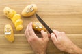 Scary face potatoes being cut on a wooden kitchen board Royalty Free Stock Photo