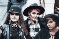 Scary family, mother, daughters celebrating halloween. Terrifying black, white skull half-face makeup and witch costumes, stylish