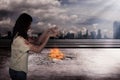 Scary female zombie with burning city background