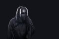 Scary figure in hooded cloak with mask in hand Royalty Free Stock Photo