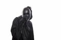 Scary figure in hooded cloak with mask in hand Royalty Free Stock Photo
