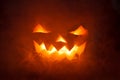 Scary Halloween Pumpkin looking through the smoke. Royalty Free Stock Photo