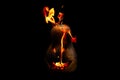 Scary Halloween pumpkin is spewing fire flame isolated on black Royalty Free Stock Photo