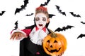 Scary Halloween vampire boy dressed up for spooky halloween party and holding an orange halloween pumpkin jack o lantern