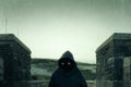 A scary, hooded figure with glowing evil eyes and blank black space where his face should be, standing on a road in the