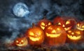 Scary Jack O Lantern pumpkins surrounded by mystical mist under moon on Halloween Royalty Free Stock Photo