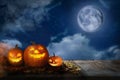 Scary Jack O Lantern pumpkins under moon on Halloween. Space for text Royalty Free Stock Photo