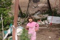 A scary little girl outside the city, A swing, different equipment and plants are visible in background, Iran, Gilan