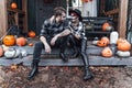 Scary love family couple man,woman celebrating halloween.Terrifying black skull half-face makeup,witch costumes.Stylish