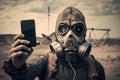 Scary mutant in gas mask for chemical protection takes a selfie, apocalyptic smoke in desert background. Nuclear