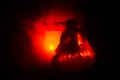 Scary orange pumpkin with carved eyes and a smile with burning candles and an ax on a dark background with fire sky. For the Hallo Royalty Free Stock Photo