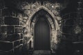 Scary pointy wooden door in an old and wet stone wall building with cross, skull and bones at both sides in black and white. Royalty Free Stock Photo