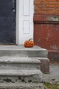 Scary pumpkin as halloween decoration stands at the front door Royalty Free Stock Photo