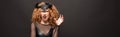 Redhead woman gesturing in halloween costume with horns on black