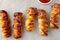 Scary sausage mummies in dough for kids party. Funny crazy Halloween food for children Royalty Free Stock Photo