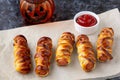 Scary sausage mummies in dough for kids party. Funny crazy Halloween food for children Royalty Free Stock Photo