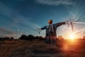 Scary scarecrow with a halloween pumpkin head in a field at sunset. Halloween background, copy space Royalty Free Stock Photo