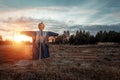 Scary scarecrow with a halloween pumpkin head in a field at sunset. Halloween background, copy space Royalty Free Stock Photo