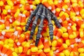 Scary skeleton hand coming out of pile of candy corn