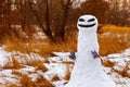 Scary snowman as a monster on a background of yellow grass. Halloween.