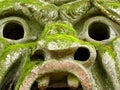 A scary stone mask moss covered