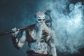 Scary undead from nord with axe in blue background with fog
