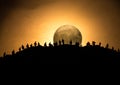 Scary view crowd of zombies on hill with spooky cloudy sky with fog and rising full moon. Silhouette group of zombie walking under Royalty Free Stock Photo