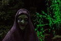 Scary witch in dark background with green fairy lights