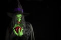 Scary witch holding an apple. Royalty Free Stock Photo