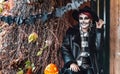 Scary woman,girl celebrating halloween.Terrifying black skull half-face skeleton makeup.Witch costume,stylish image Royalty Free Stock Photo