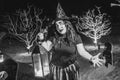 Scary woman witch with face pant during Halloween party at the artificial cemetery on the beach