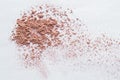 Scattered beige powder, Crumbles natural makeup powder on white background