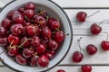 Scattered berries of ripe cherries on a light wooden background and in a bowl. Top view. Seasonal Vitamins Royalty Free Stock Photo