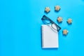 Scattered candies near optical glasses in black plastic frame and blank notepad