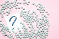 Scattered candies with question sign on a pink background