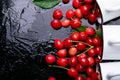 Scattered cherry from enamel cups. Cherries in iron cup on black background. Healthy, summer fruit. Cherries. Three. Top view. Royalty Free Stock Photo