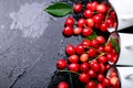 Scattered cherry from enamel cups. Cherries in iron cup on black background. Healthy, summer fruit. Cherries. Three. Top view. Royalty Free Stock Photo