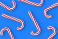 Scattered Christmas canes, candy with red stripes on blue background Royalty Free Stock Photo
