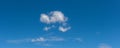 Scattered clouds floating across blue sky panoramic vista Royalty Free Stock Photo