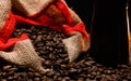 scattered coffee beans in a jute bag on a wooden background Royalty Free Stock Photo