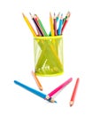 Scattered colored pencils with green metal holder with colored pencils on white background Royalty Free Stock Photo