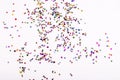 Scattered colored sequins of various shapes on a white background Royalty Free Stock Photo