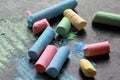 Scattered colorful crayon chalks on black boar