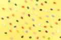 Scattered colorful jelly bean sweets on yellow background Royalty Free Stock Photo