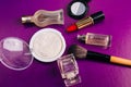 Scattered cosmetics on a purple background. The contents of women`s handbags. Lady set. Lipstick, perfume and shadow. View from Royalty Free Stock Photo