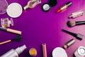 Scattered cosmetics on a purple background. The contents of women`s handbags. Lady set. Lipstick, perfume and shadow. View from Royalty Free Stock Photo