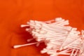 Scattered cotton swabs for the ears on an orange background Royalty Free Stock Photo