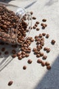 Scattered glass jar with coffee beans on a gray table, close-up Royalty Free Stock Photo